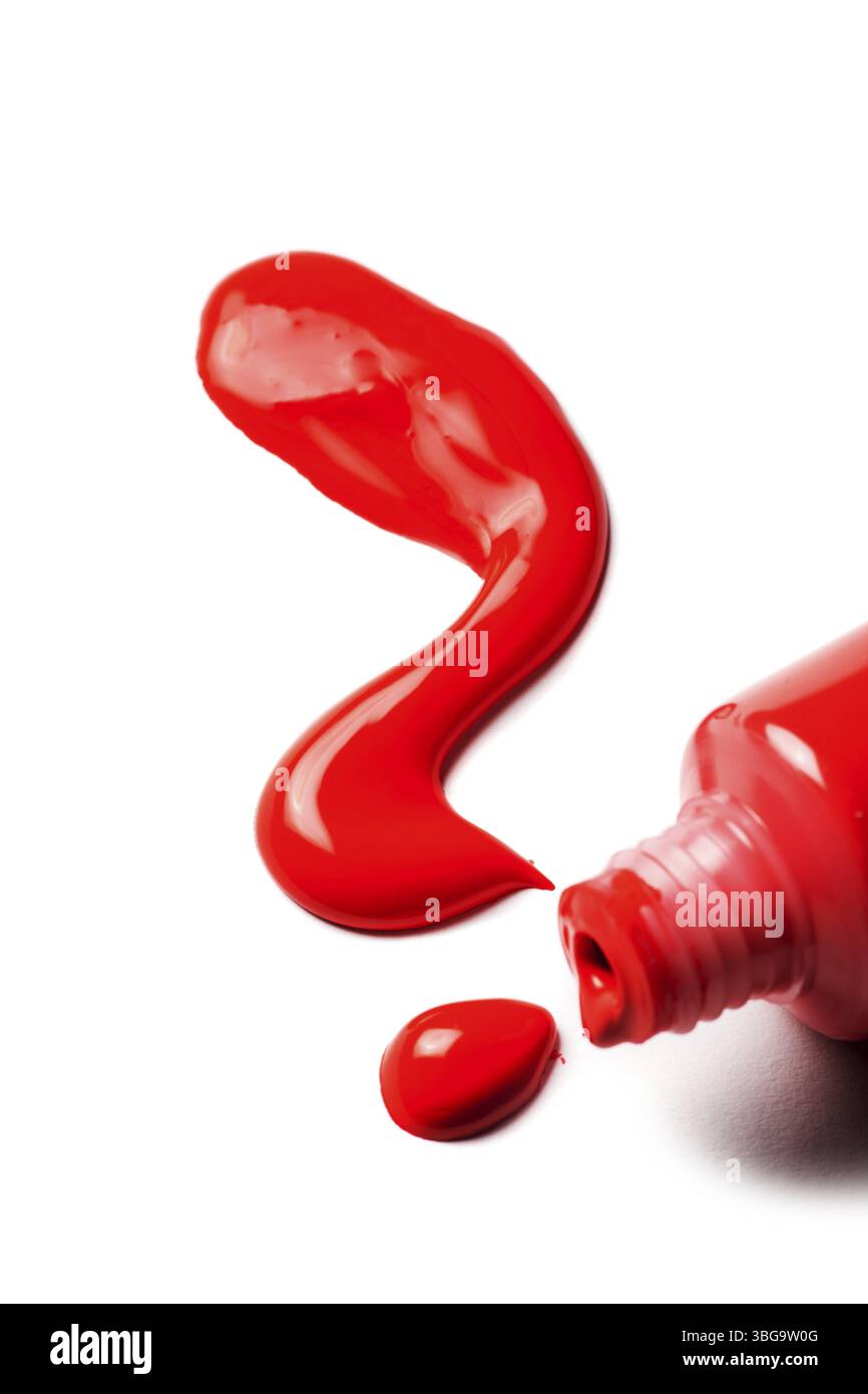 Primo piano di un tubo aperto di pittura artistica con vernice acrilica rossa che fuoriesce a forma di punto interrogativo su sfondo bianco Foto Stock