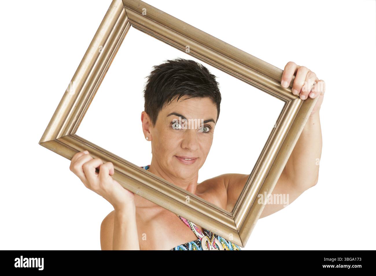 Vista della parte superiore del corpo di una donna di mezza età dai capelli neri con cornice dorata su sfondo bianco, Berlino, Germania, Europa Foto Stock