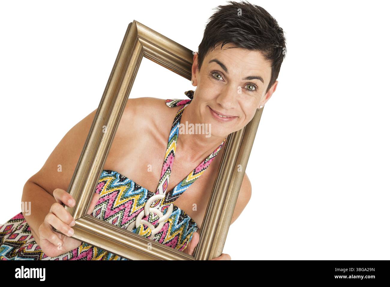 Vista della parte superiore del corpo di una donna di mezza età dai capelli neri con cornice dorata su sfondo bianco, Berlino, Germania, Europa Foto Stock