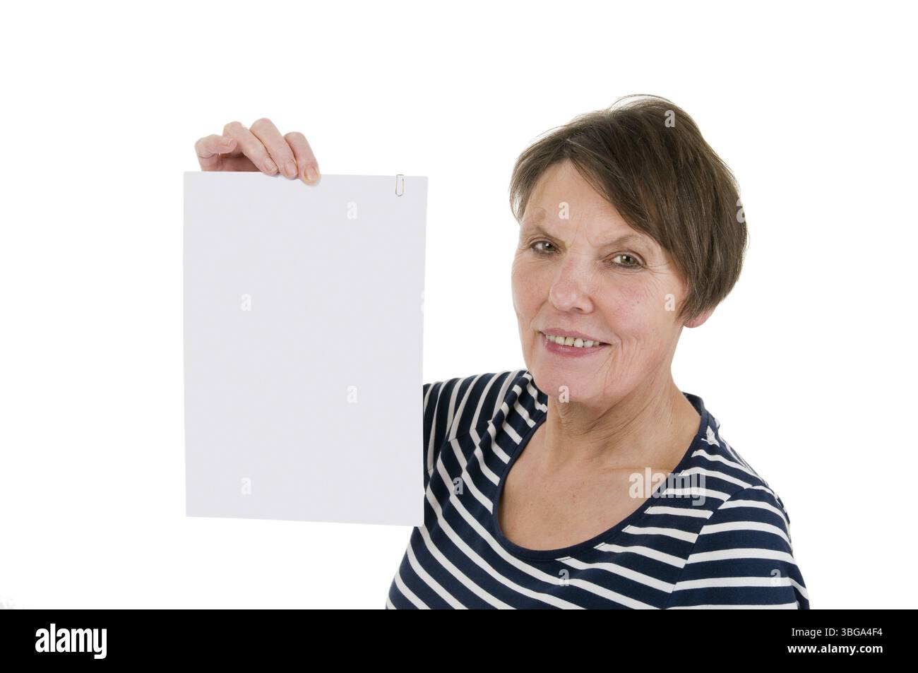 Vista testa e spalle di una donna matura con una camicia a righe che regge un documento A4 all'altezza della testa verso lo spettatore, che guarda amichevole nel cameriere Foto Stock