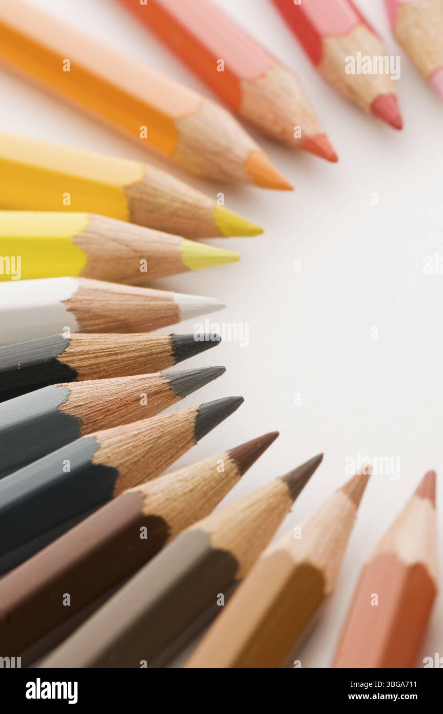 Vista elevata delle punte a matita colorate disposte in semicerchio in marrone e rosso su carta da disegno con nitidezza selettiva Foto Stock