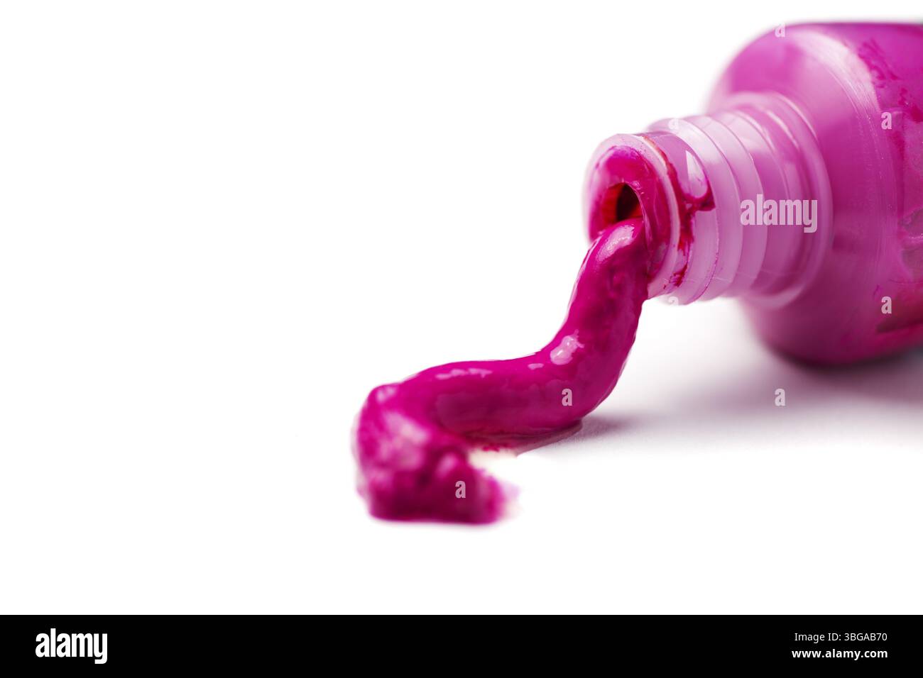 Primo piano di un tubo aperto di pittura magenta che fuoriesce su uno sfondo bianco Foto Stock