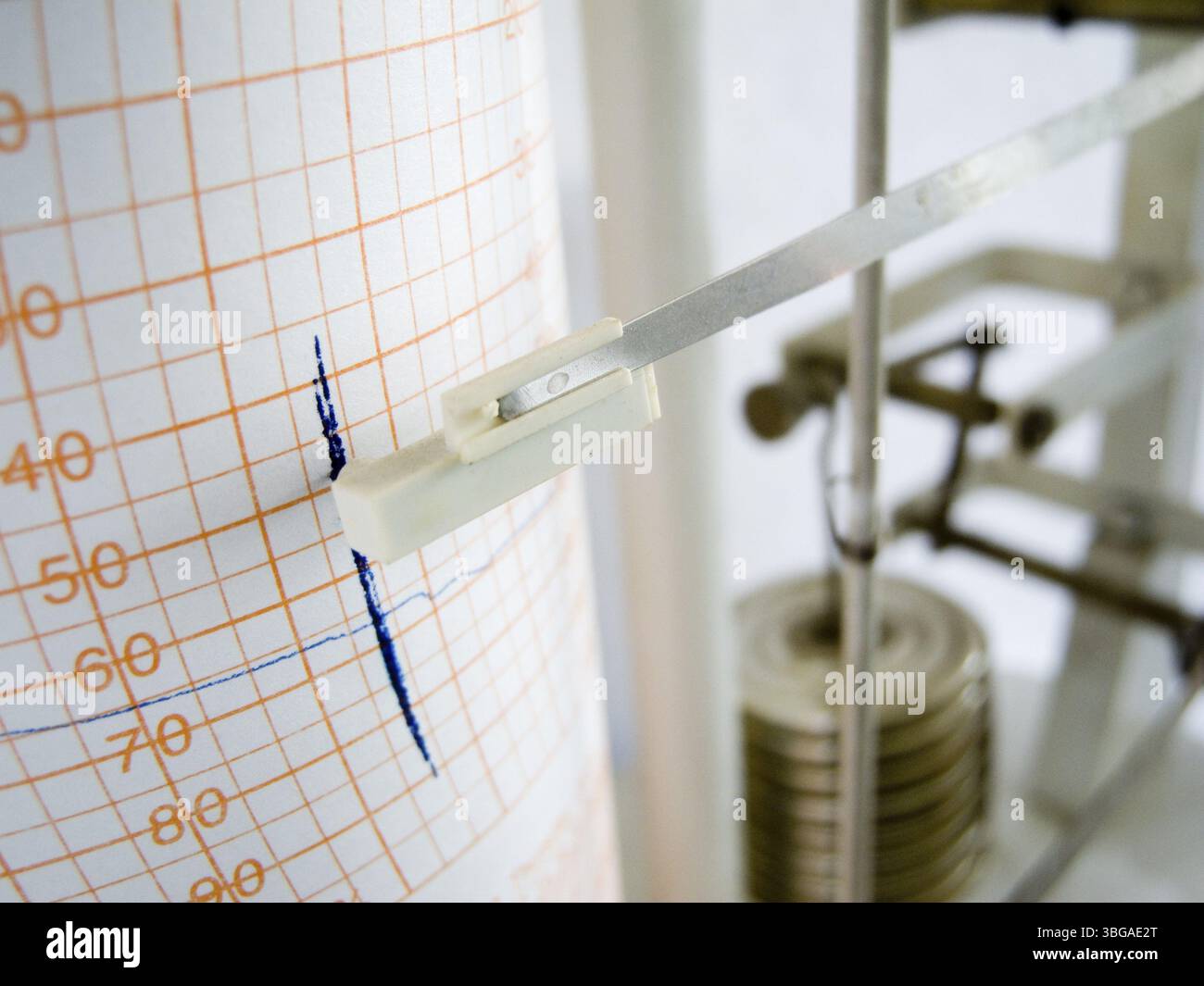 Primo piano di un registratore meteorologico con pennarello blu su carta da parati e aste meccaniche Foto Stock