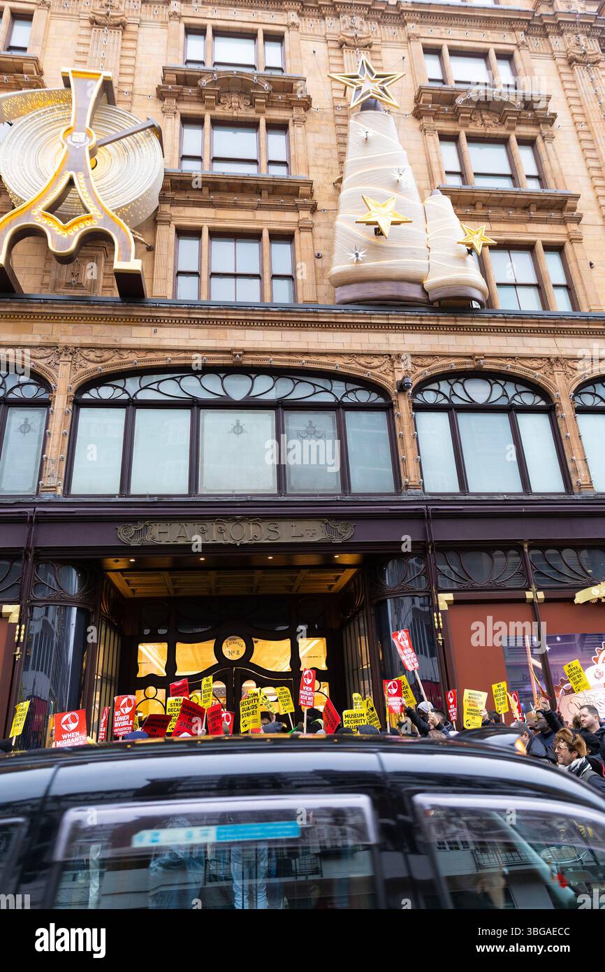 I manifestanti si radunano fuori dai grandi magazzini Harrods a Londra mentre i lavoratori Harrods rappresentati dalla United Voices of the World union sono in sciopero. Foto Stock