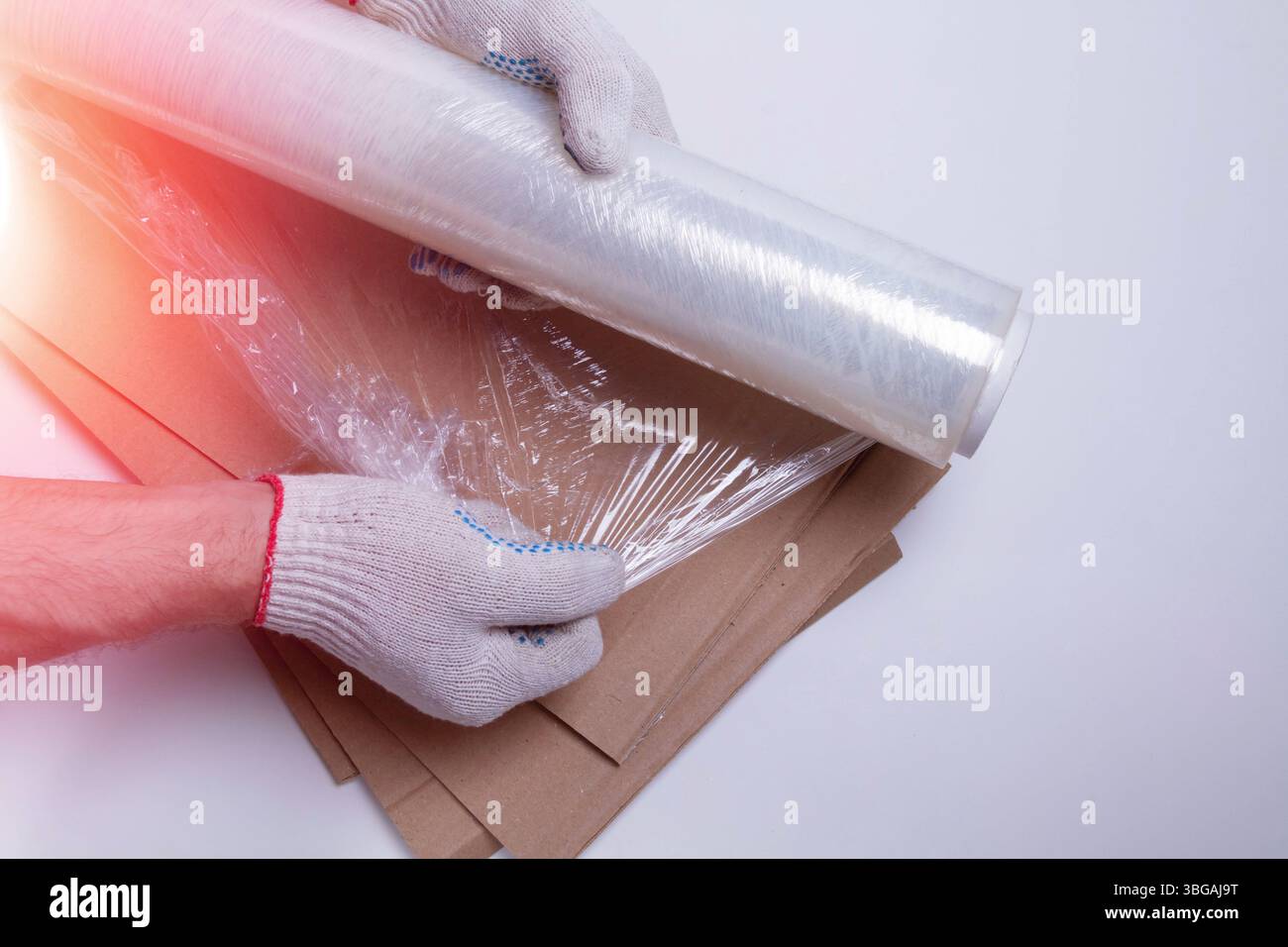 Materiale di imballaggio. Film estensibile e imballaggio in cartone su sfondo bianco. Imballaggio della merce prima della spedizione. Foto Stock