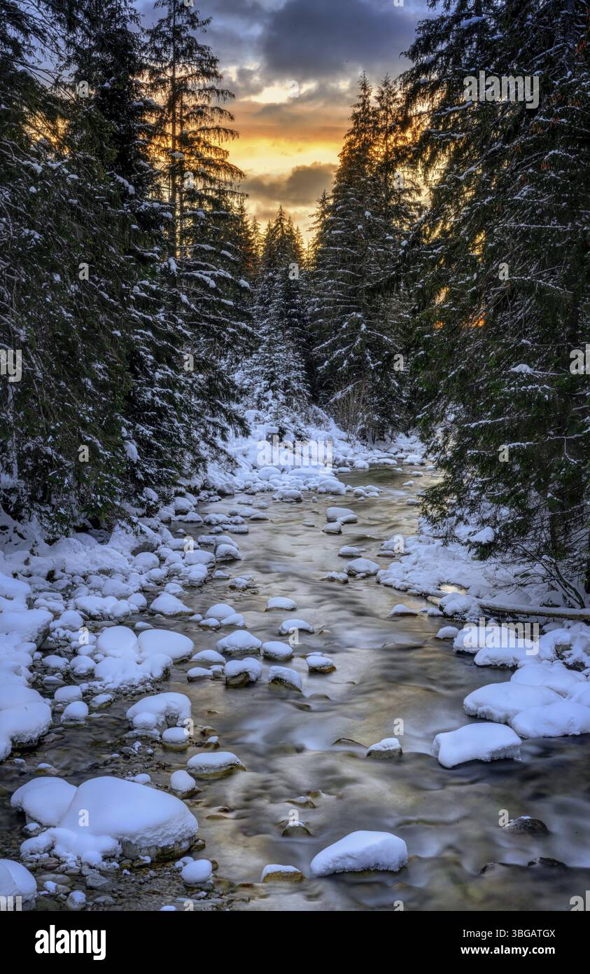 Fiume Bela vicino a Podbanske in inverno con neve al tramonto in Slovacchia Foto Stock