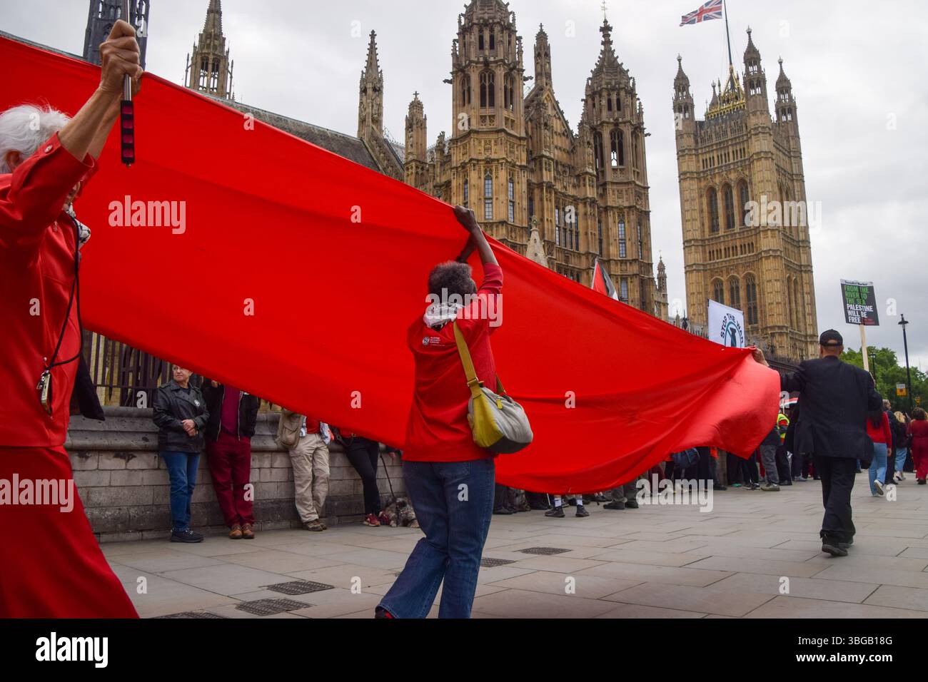 Londra, Regno Unito. 4 giugno 2025. I manifestanti detengono un lungo tessuto rosso fuori dalle camere del Parlamento che simboleggia le "linee rosse” attraversate da Israele, durante una manifestazione pro-Palestina. I manifestanti pro-palestinesi hanno organizzato una protesta chiedendo un embargo sulle armi contro Israele, che gli aiuti vengono erogati alla popolazione affamata di Gaza e che Israele interrompe i suoi attacchi. Credito: SOPA Images Limited/Alamy Live News Foto Stock