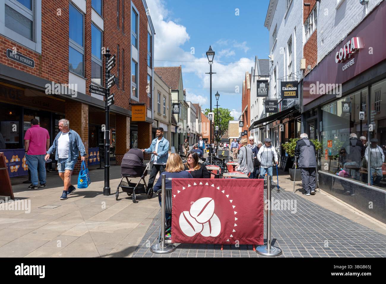 Vista lungo Bury Street nel centro di Abingdon, Oxfordshire, Inghilterra, Regno Unito, una strada pedonale trafficata con persone sedute ai tavoli esterni Foto Stock