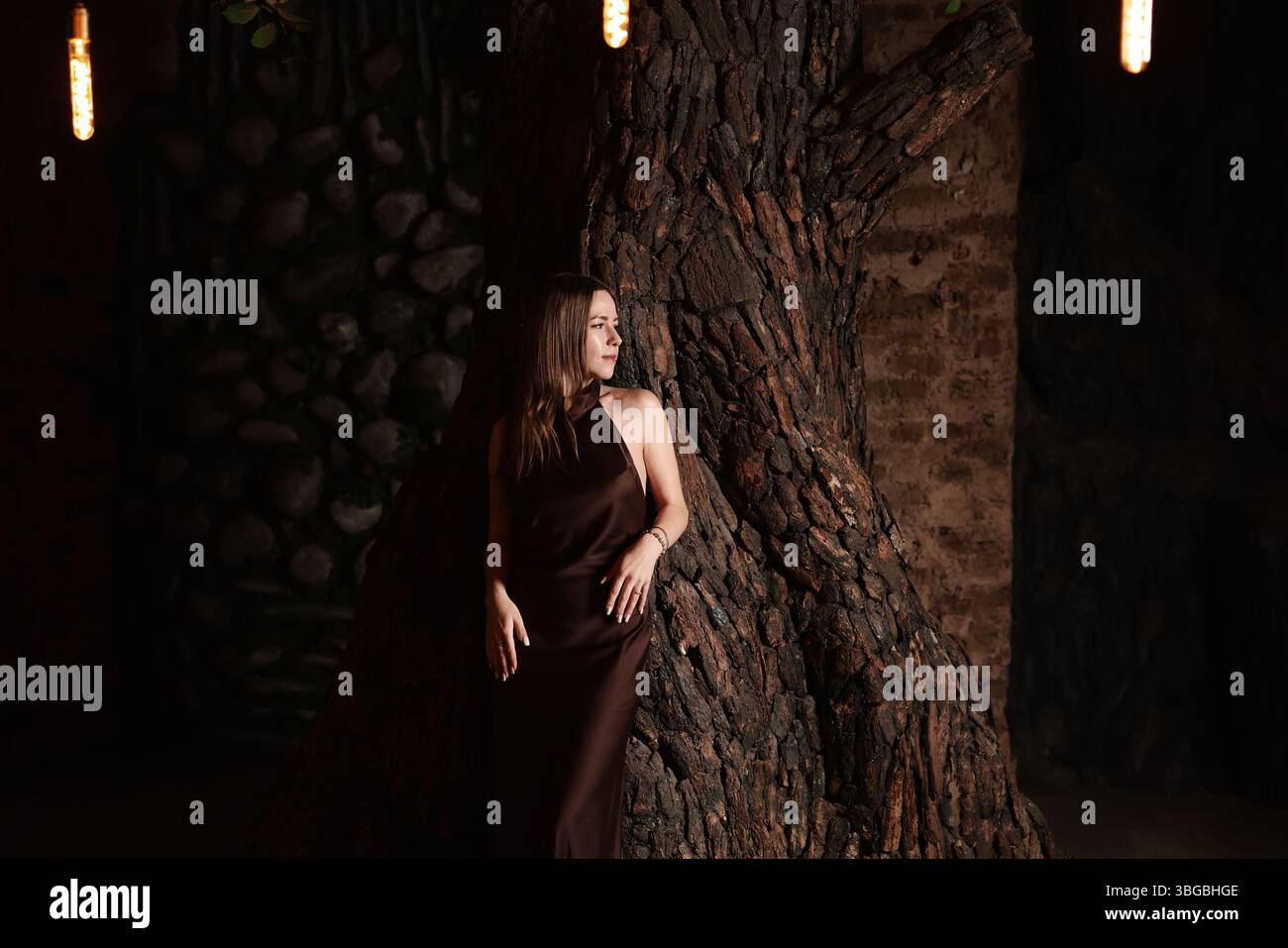 Un modello elegante che poggia graziosamente su uno splendido sfondo rustico in Natures Glow Foto Stock