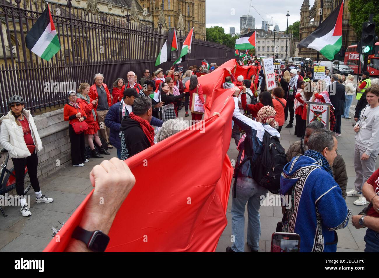 Londra, Regno Unito. 4 giugno 2025. I manifestanti pro-palestinesi si riuniscono fuori dalle camere del Parlamento chiedendo un embargo sulle armi contro Israele, che Israele interrompa i suoi attacchi a Gaza e che gli aiuti vengono erogati alla popolazione affamata. Centinaia di manifestanti tenevano un lungo tessuto rosso intorno al parlamento, simboleggiando le "linee rosse” attraversate da Israele. Crediti: Vuk Valcic/Alamy Live News Foto Stock