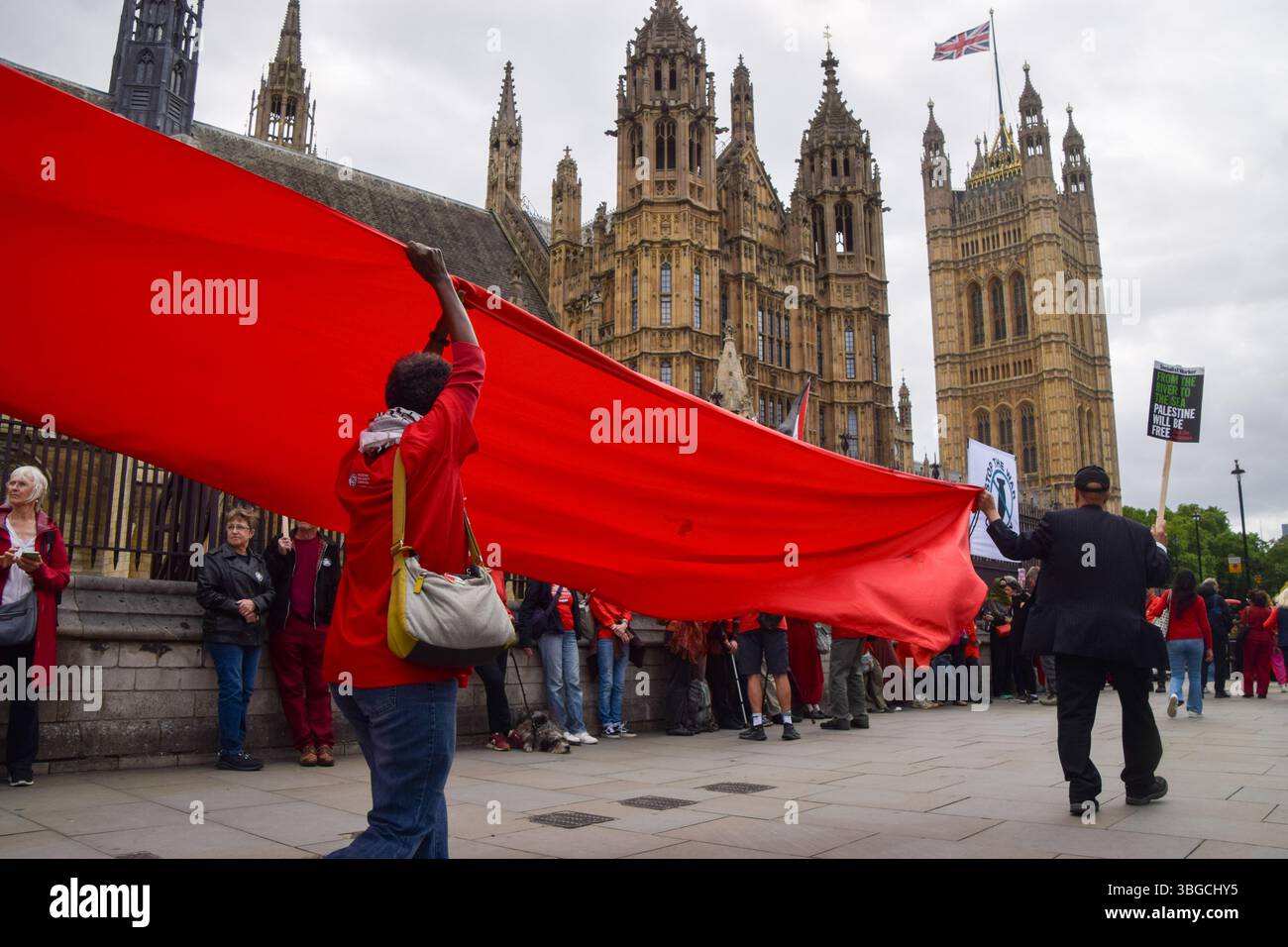 Londra, Regno Unito. 4 giugno 2025. I manifestanti pro-palestinesi si riuniscono fuori dalle camere del Parlamento chiedendo un embargo sulle armi contro Israele, che Israele interrompa i suoi attacchi a Gaza e che gli aiuti vengono erogati alla popolazione affamata. Centinaia di manifestanti tenevano un lungo tessuto rosso intorno al parlamento, simboleggiando le "linee rosse” attraversate da Israele. Crediti: Vuk Valcic/Alamy Live News Foto Stock