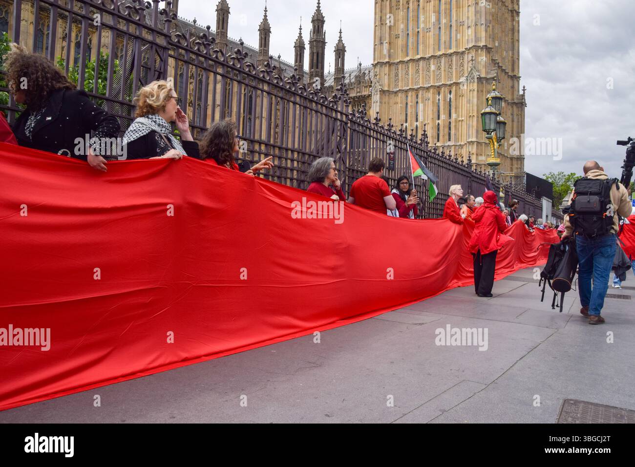 Londra, Regno Unito. 4 giugno 2025. I manifestanti pro-palestinesi si riuniscono fuori dalle camere del Parlamento chiedendo un embargo sulle armi contro Israele, che Israele interrompa i suoi attacchi a Gaza e che gli aiuti vengono erogati alla popolazione affamata. Centinaia di manifestanti tenevano un lungo tessuto rosso intorno al parlamento, simboleggiando le "linee rosse” attraversate da Israele. Crediti: Vuk Valcic/Alamy Live News Foto Stock