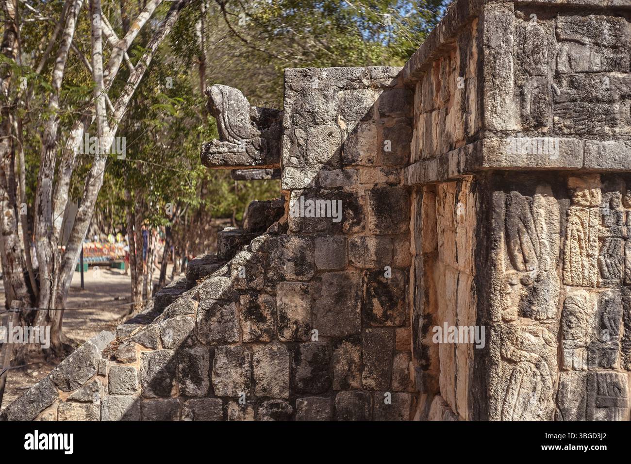 Scultura con testa di serpente in pietra all'angolo di una rovina maya a chichén Itzá, messico, che mostra l'antica architettura e il patrimonio culturale Foto Stock