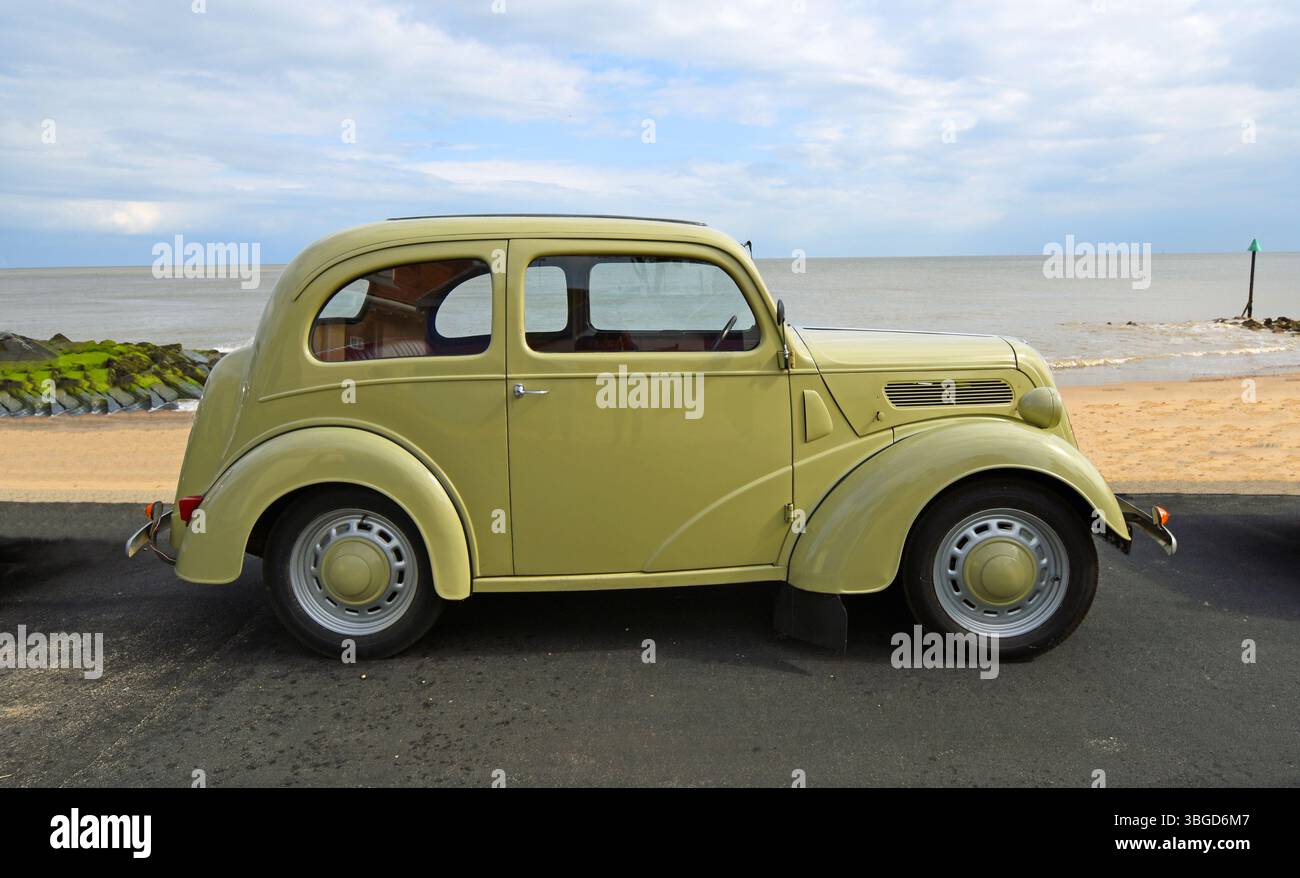 Classica Ford Anglia parcheggiata sul lungomare, spiaggia e mare sullo sfondo Foto Stock