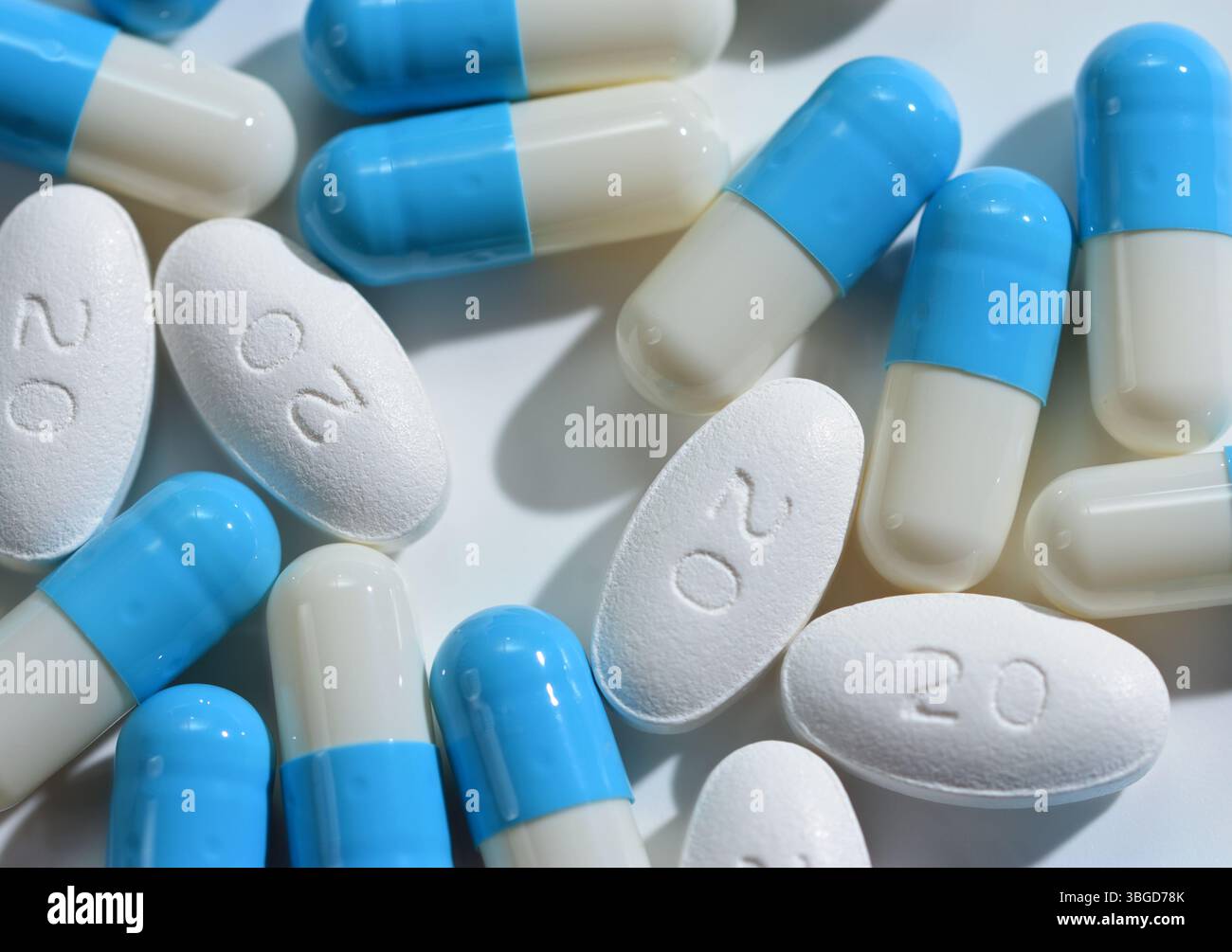 Compresse rivestite con film di atorvastatina 20mg e capsule di Omeprazolo blu e bianco raggruppate su sfondo bianco Foto Stock