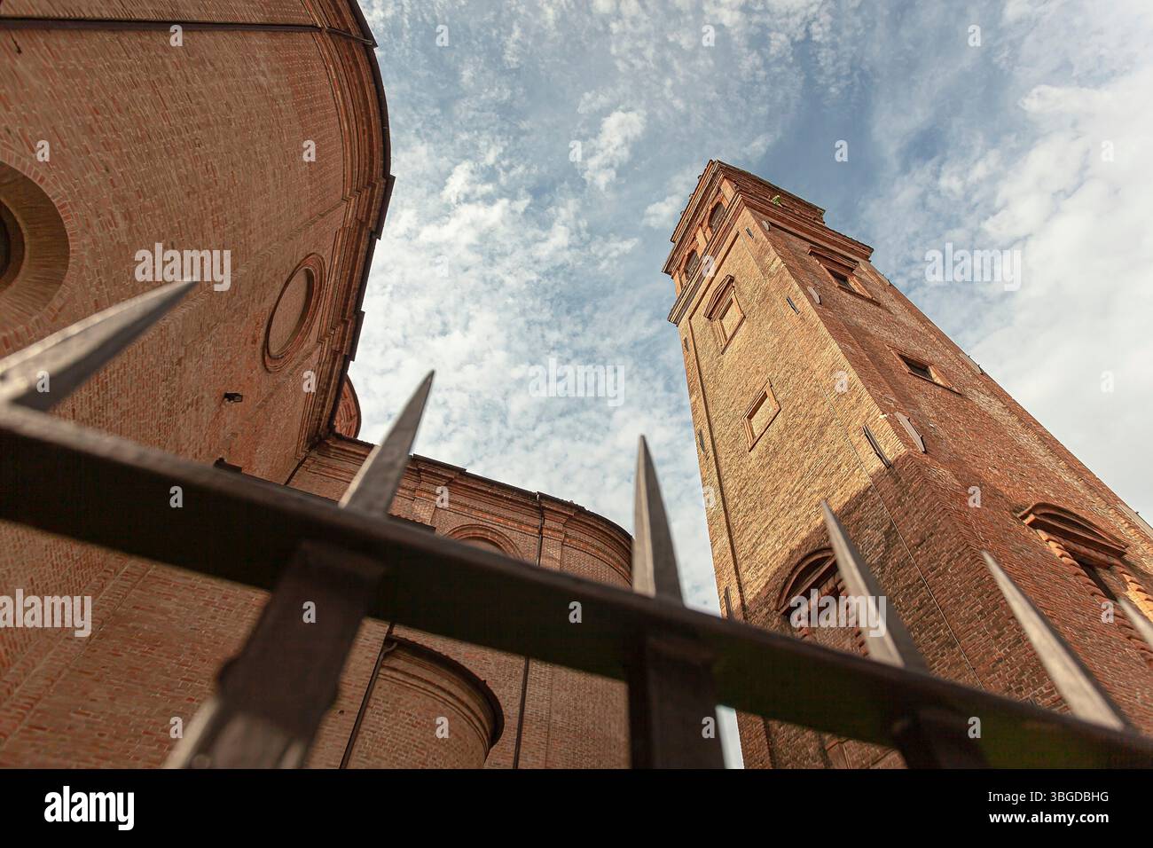 Ferrara, Italia 2 gennaio 2025: Veduta ad angolo basso del Duomo di ferrara e del suo campanile distaccato visto attraverso una recinzione metallica, che mostra l'architec italiano Foto Stock