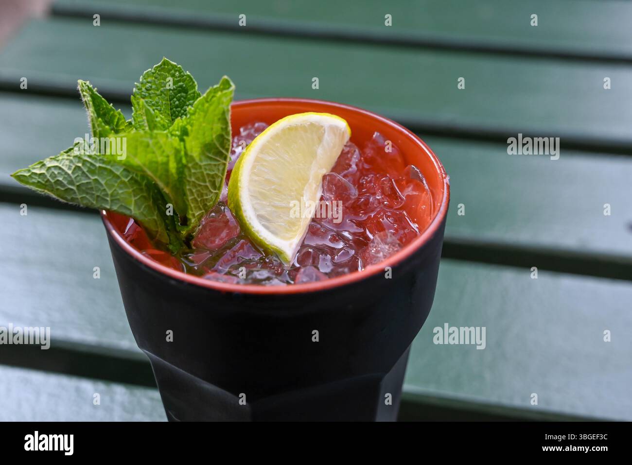 bicchiere di cocktail mohito con ghiaccio tritato, lime e menta Foto Stock