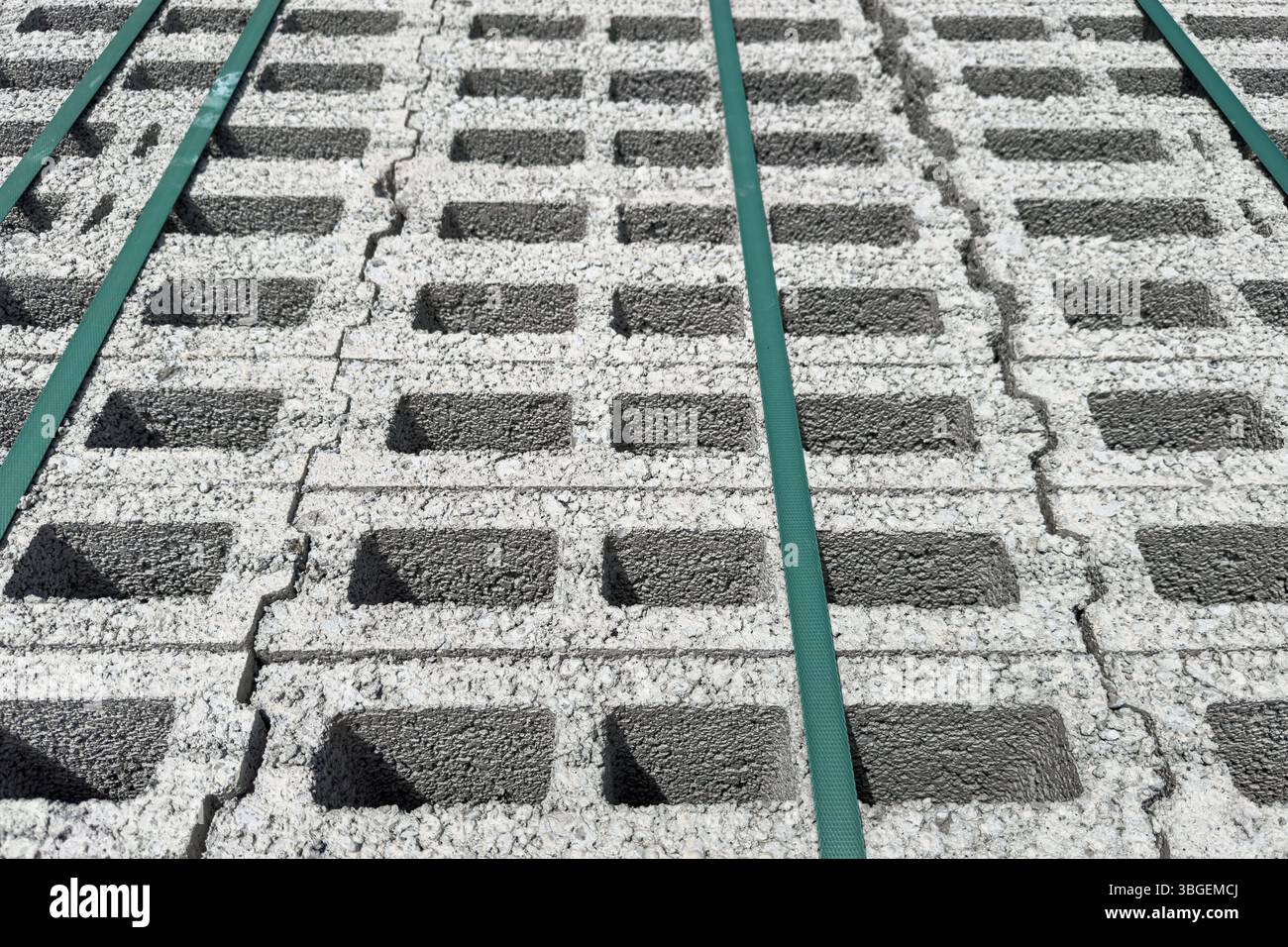 Blocchi di calcestruzzo cellulare impilati visti dall'alto con cinghie verdi che fissano il carico. Niente persone. Adatto per le costruzioni e gli sfondi industriali Foto Stock