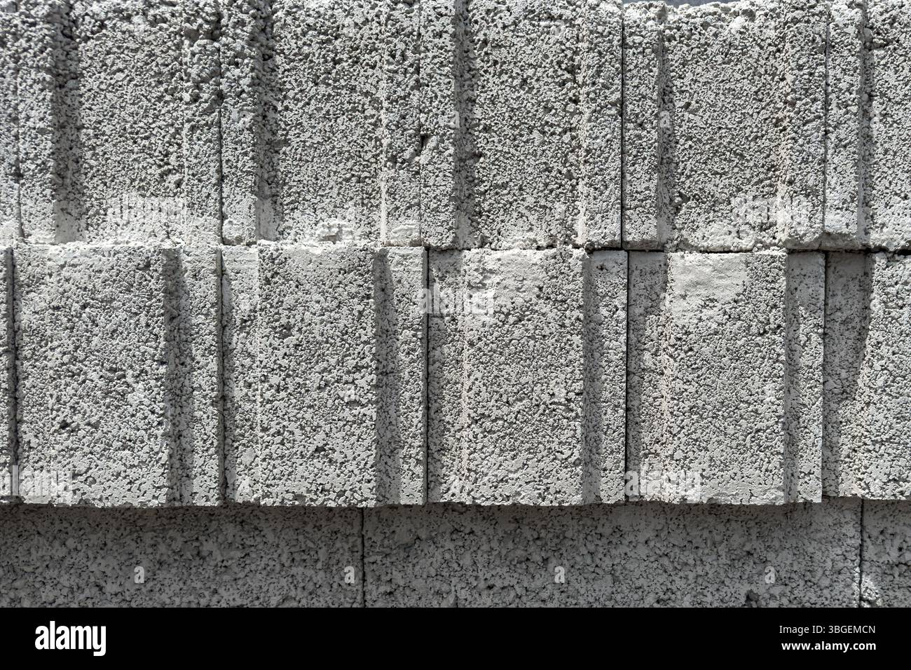 Primo piano di blocchi di calcestruzzo cellulare impilati con trama ruvida e linee verticali. Adatto per la costruzione, gli sfondi in texture e l'uso industriale. Foto Stock