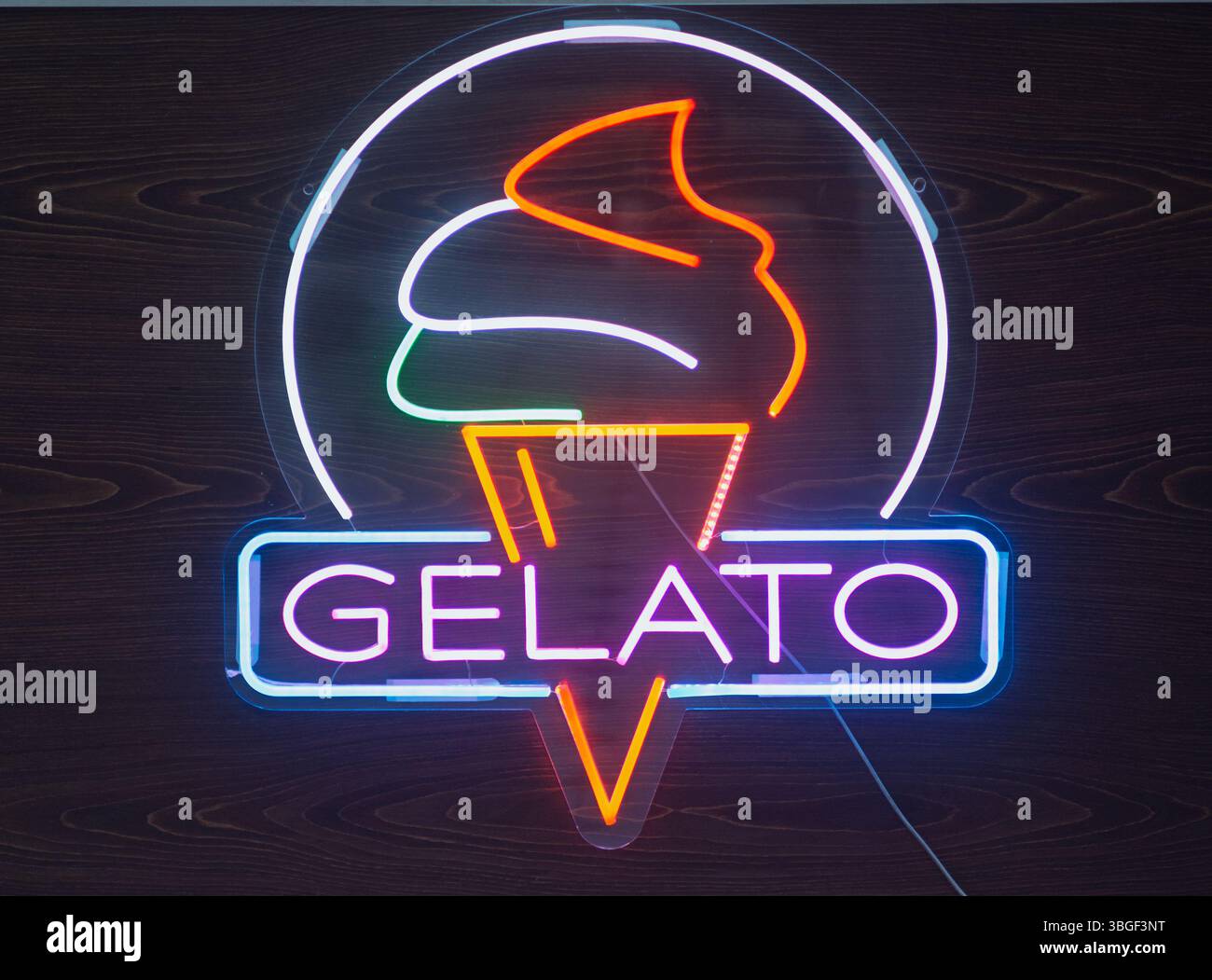 Colorato cartello gelato al neon su sfondo legno scuro Foto Stock