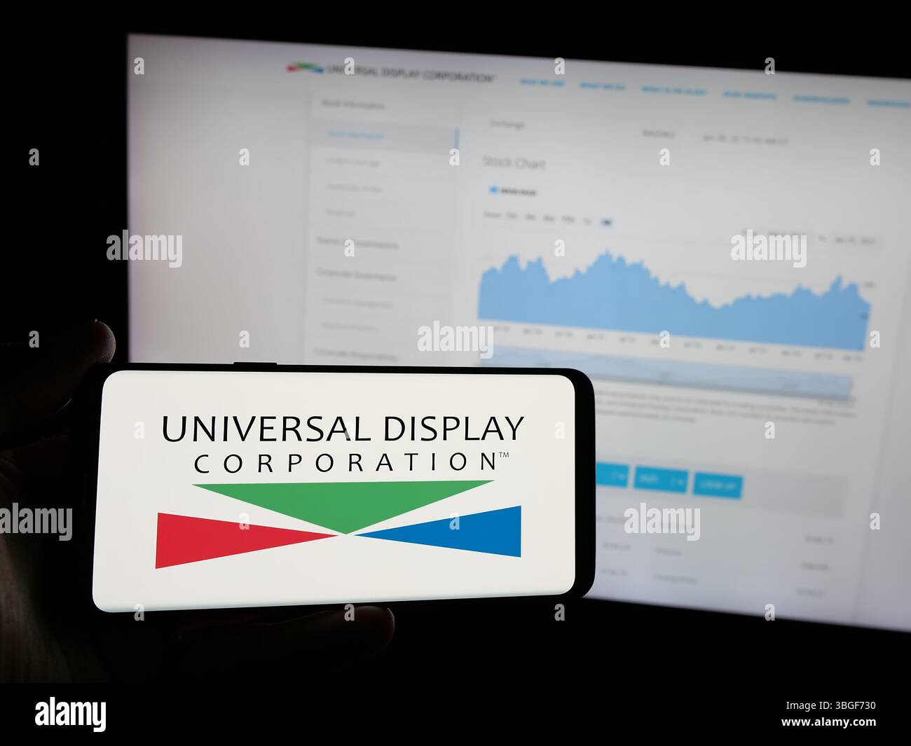 Stoccarda, Germania - 01-31-2025: Persona che possiede uno smartphone con il logo della società statunitense OLED Universal display Corporation sullo schermo di fronte al sito Web. Foto Stock