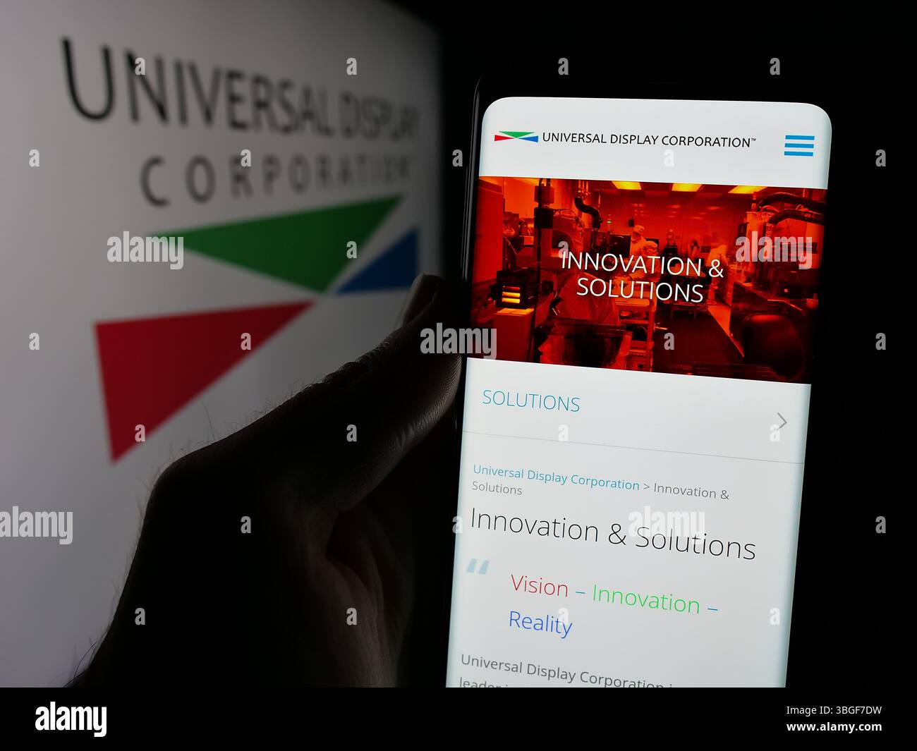 Stoccarda, Germania - 01-31-2025: Persona che detiene il cellulare con pagina web della società statunitense OLED Universal display Corporation sullo schermo con logo. Foto Stock