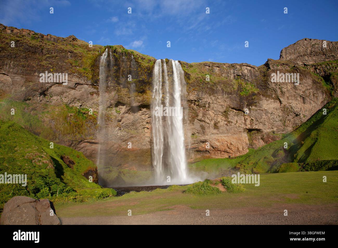 L'iconica cascata di Seljalandsfoss sulla costa meridionale dell'Islanda ha un sentiero che consente ai visitatori di camminare dietro l'acqua a cascata Foto Stock