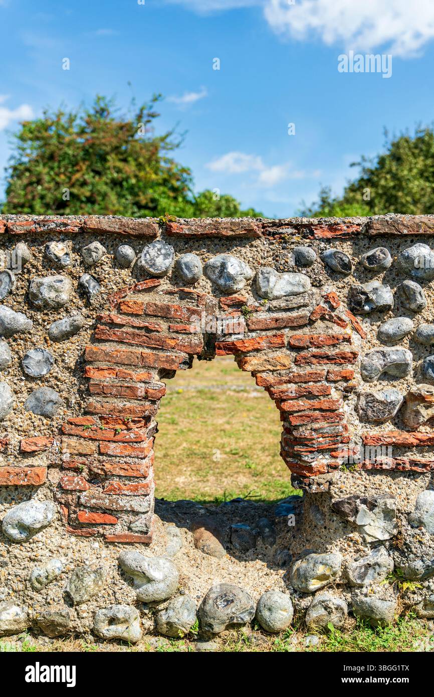 Piccolo arco nei resti delle mura in pietra del bagno del III secolo presso il castello romano di Richborough. Pietre con piastrelle rosse che compongono l'arco, Foto Stock