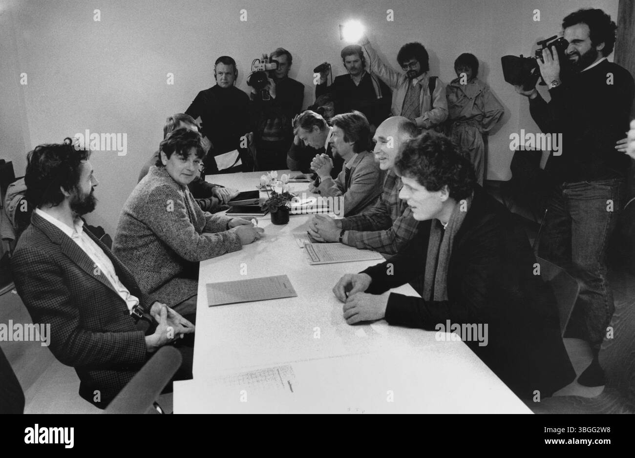 Joschka Fischer (Mitte links, im karierten Sakko) während seiner ersten offiziellen Pressekonferenz als Minister für Umwelt und energie des Landes Hessen AM 13. Dezember 1985 a Wiesbaden. Die Aufnahme zeigt ihn und weitere Mitglieder der Grünen Landesregierung an einem langen Besprechungstisch, umgeben von Journalistinnen, Fotografinnen und Kamerateams. Der Tag markierte einen politischen Wendepunkt – Die erste Regierungsbeteiligung der Grünen in einem deutschen Bundesland. Foto Stock