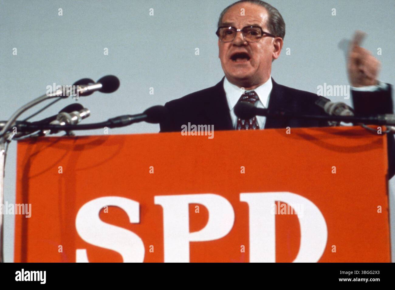 Herbert Wehner spricht leidenschaftlich am SPD-Rednerpult, zahlreiche Mikrofone vor ihm, grauer Hintergrund. Foto Stock