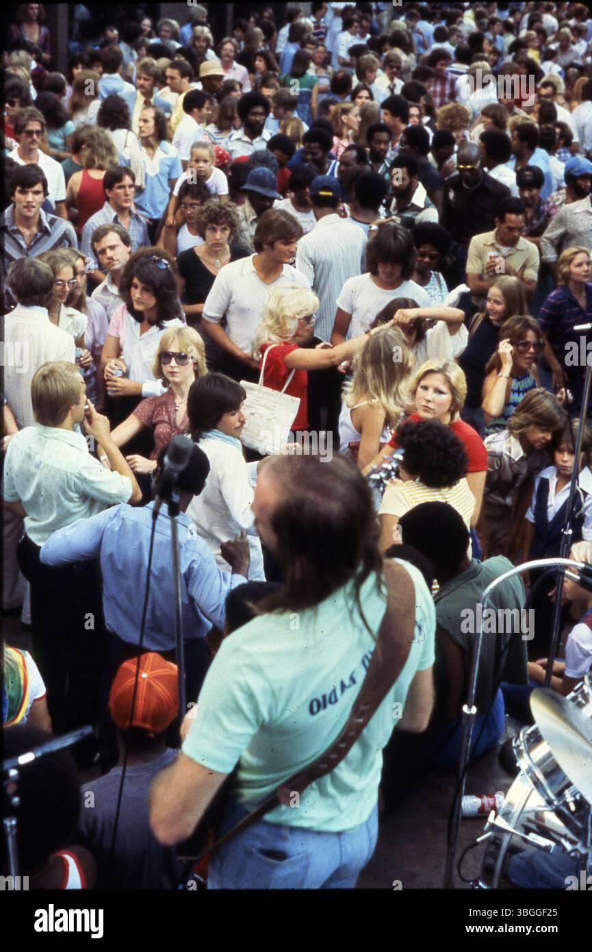 Guarda da dietro un chitarrista e un batterista sul palco che si esibisce per la folla durante il Rally in the Alley. Questo evento settimanale, sponsorizzato dai Columbus Jaycees, mirava a promuovere il centro di Columbus e fornire intrattenimento alla comunità. Foto Stock