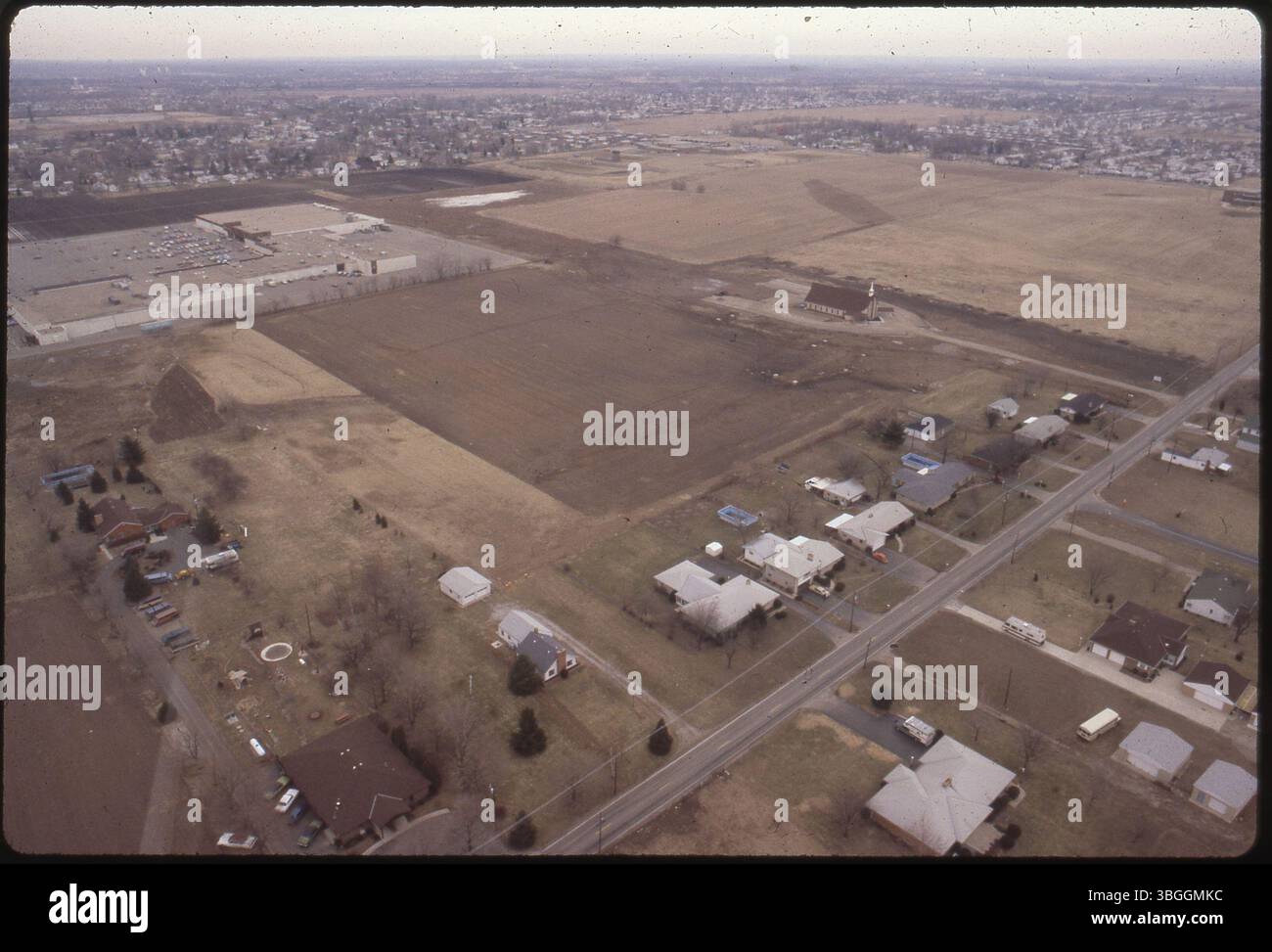 Nel febbraio 1981, una vista aerea cattura l'area aperta su Beth Ann Drive prima dello sviluppo dei Camellia Court Apartments. Obetz Road è visibile in basso a destra, con Good Shepherd Community Church e Southland Mall visibili nelle vicinanze. La terra fu rizonata da residenziale istituzionale a residenziale a bassa densità, segnando l'inizio di una nuova comunità di appartamenti nella zona. Foto Stock