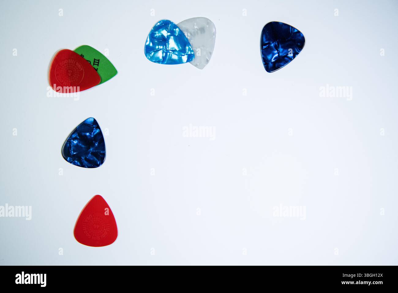 Una selezione di chitarre colorate su sfondo bianco, accessori musicali per chitarristi e musicisti. Foto Stock