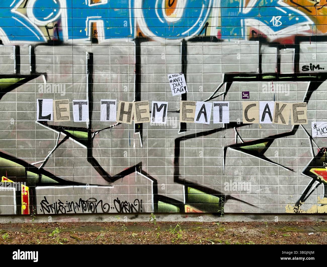 Lasciategli mangiare la torta Street art promuovendo la giornata internazionale senza dieta a Berlino, Germania Foto Stock