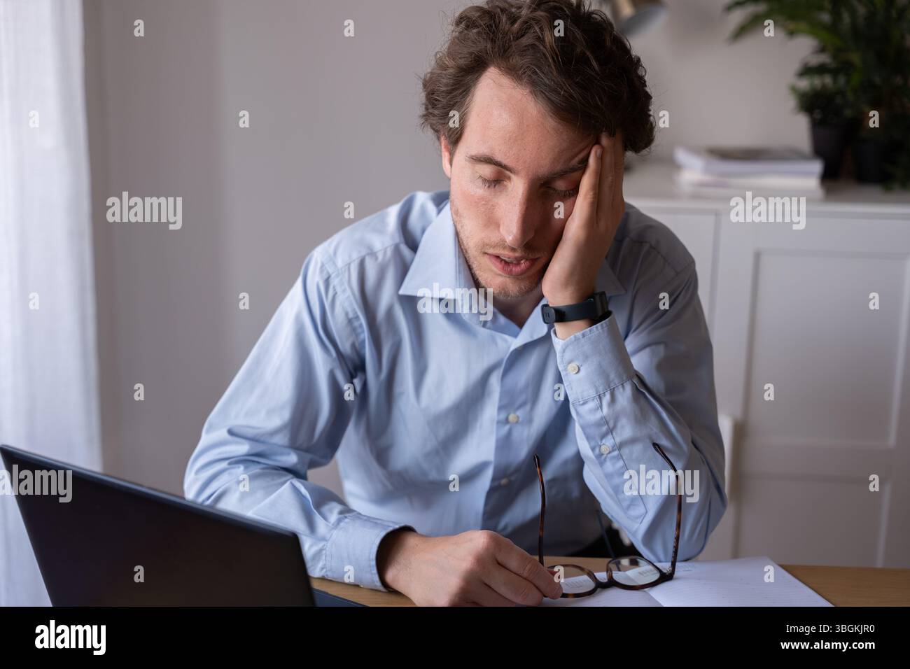 Dipendente che lavora sotto stress e privazione del sonno Foto Stock