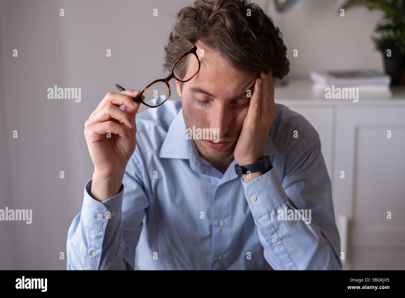 Dipendente che lavora sotto stress e privazione del sonno Foto Stock