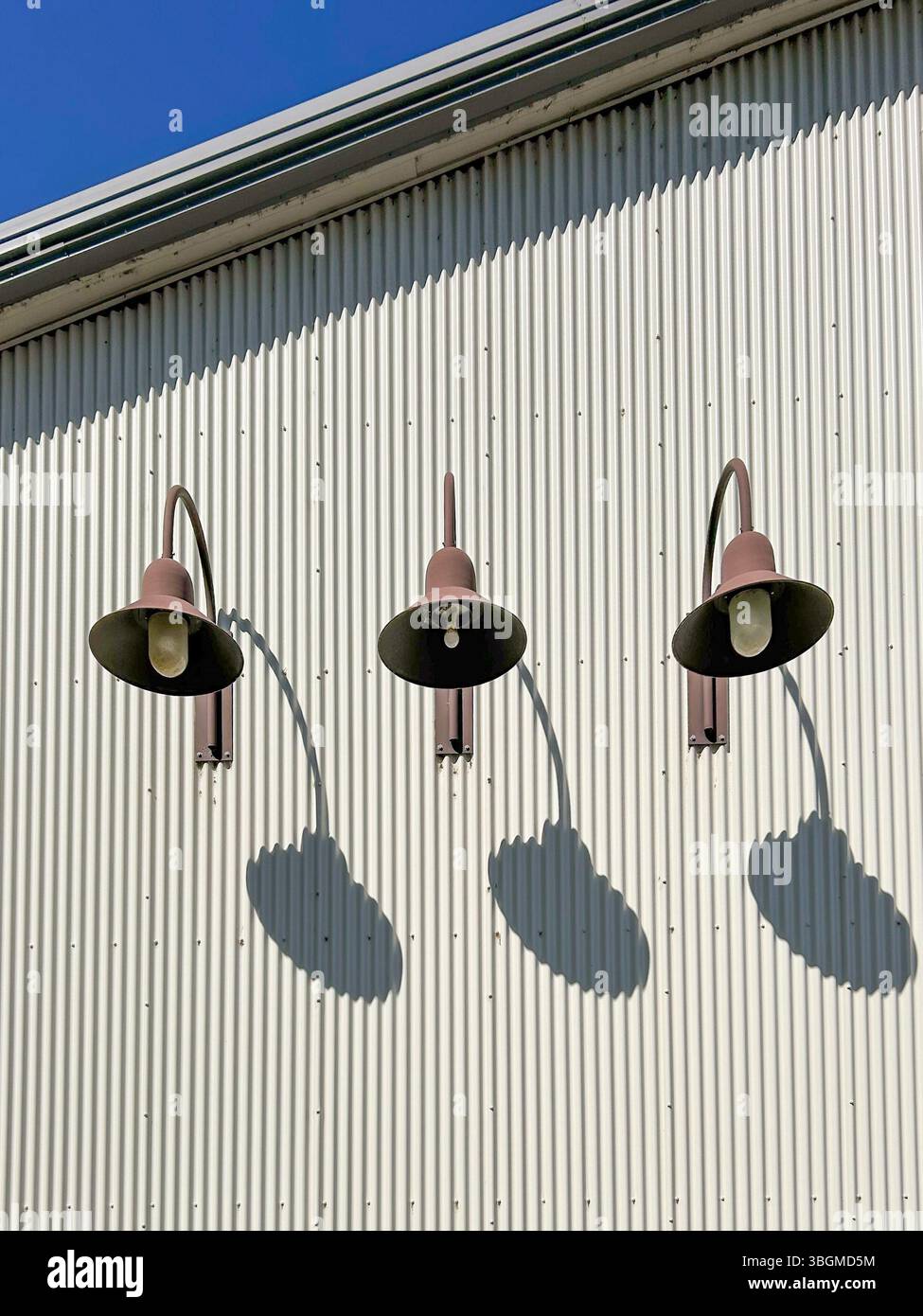 Tre luci esterne in forte ombra su un edificio Foto Stock
