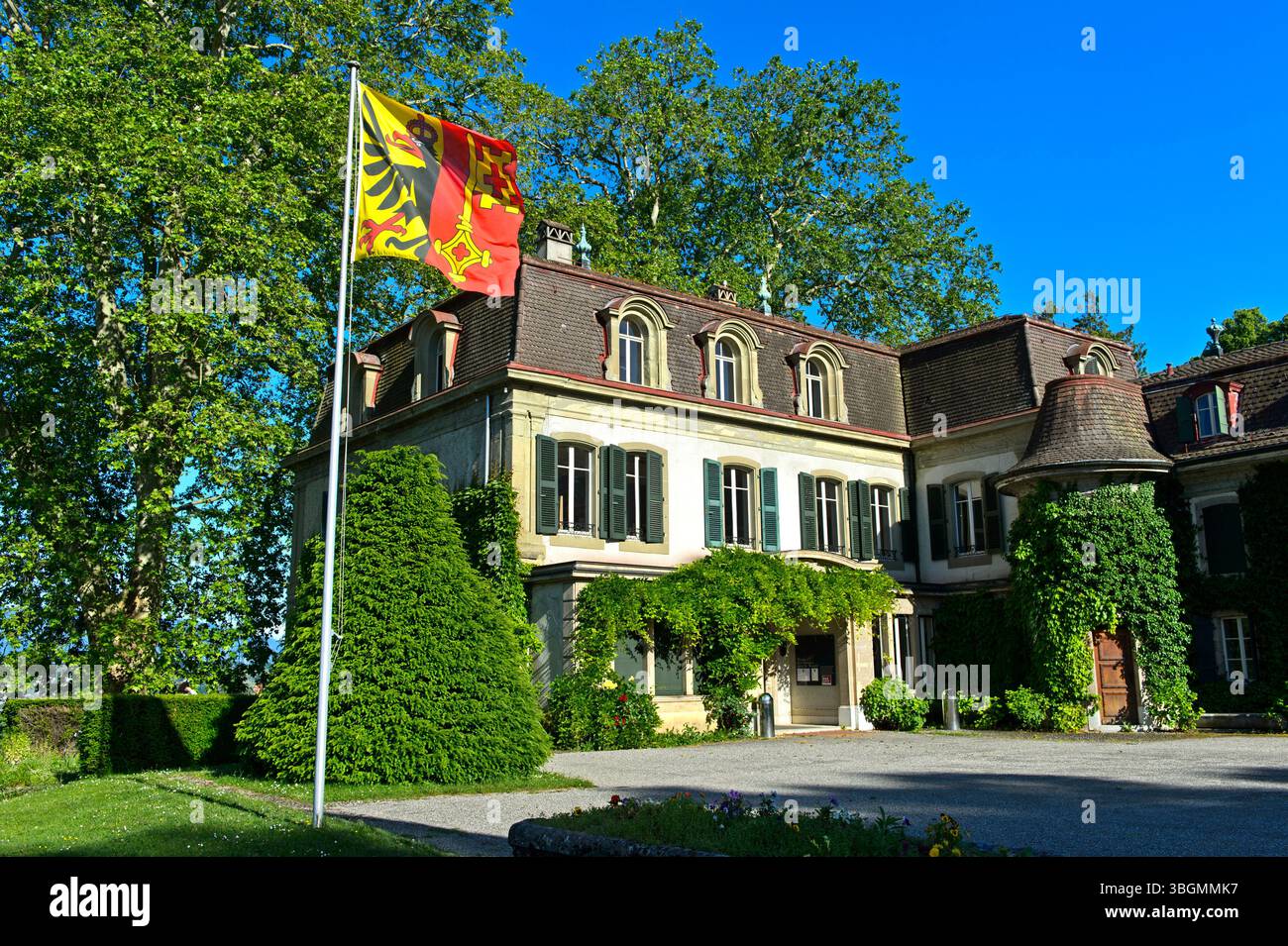 Chäteau de Penthes con la bandiera del Cantone di Ginevra nel parco Domaine du Chäteau de Penthes, Pregny-Chambesy, Ginevra, Svizzera Foto Stock