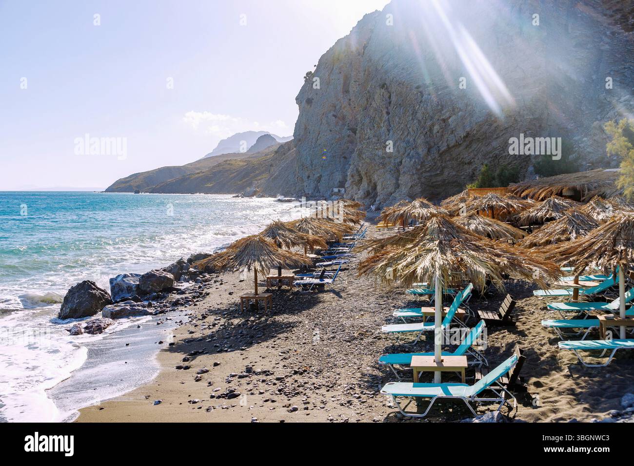 Spiaggia di sabbia e ciottoli Spiaggia Embros Thermes e piscina termale sull'isola di Kos in Grecia retroilluminata Foto Stock