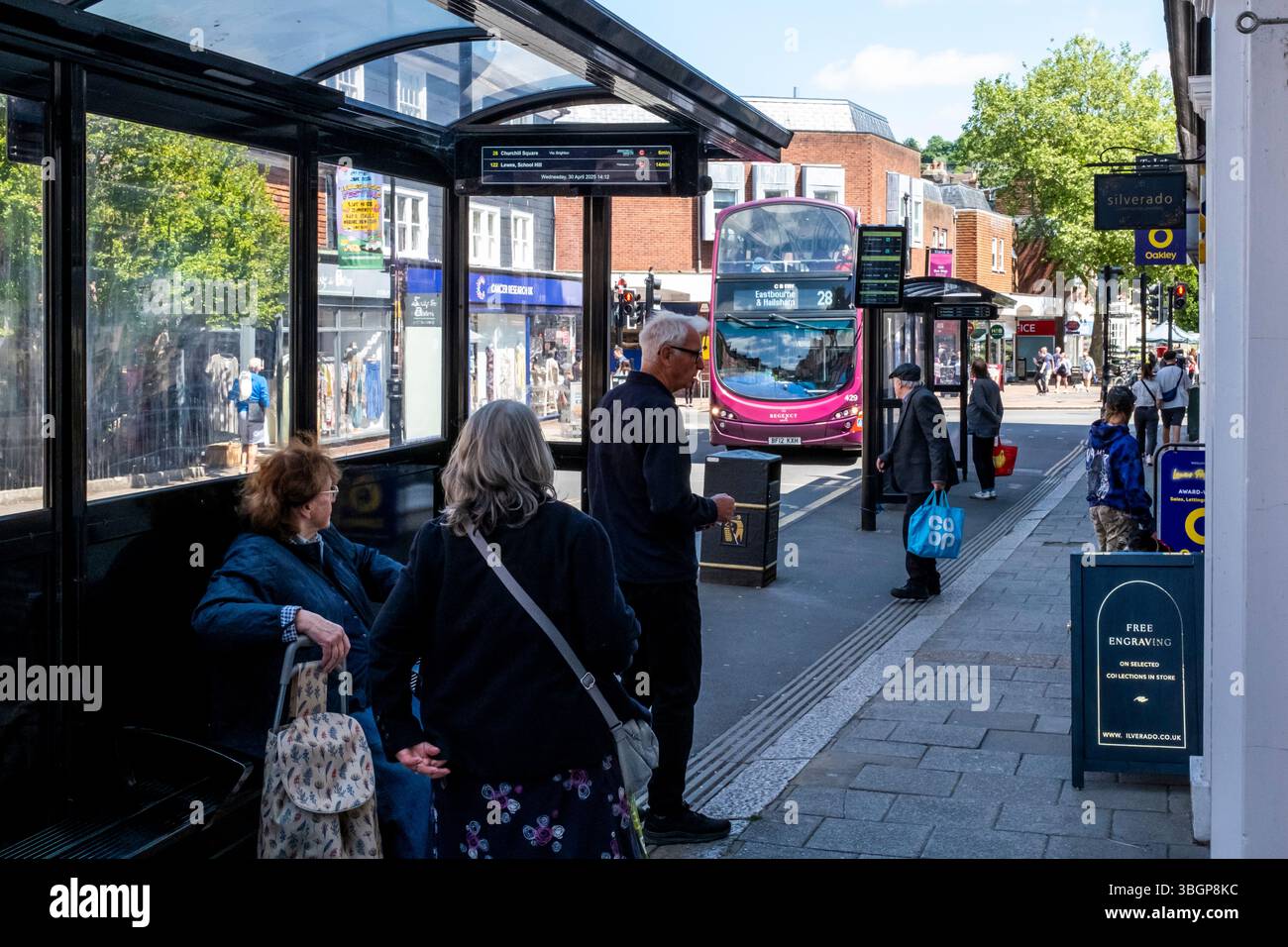 Gente del posto in attesa di Un autobus in High Street, Lewes, East Sussex, Regno Unito. Foto Stock