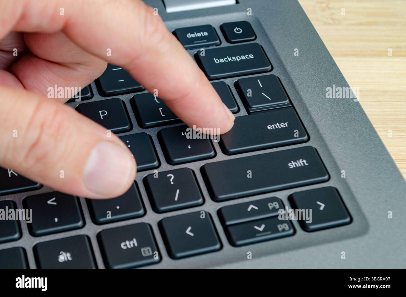 Dito sul touchpad del notebook che mostra l'interazione dell'utente vulnerabile alle minacce informatiche nascoste. Foto Stock