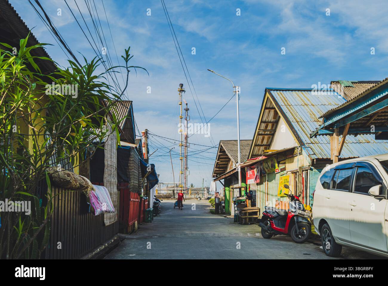 Balikpapan, Indonesia - 19 aprile 2025. Quella donna che tira il carro dei galloni d'acqua è un abitante locale della Kampung Atas Air. Foto Stock
