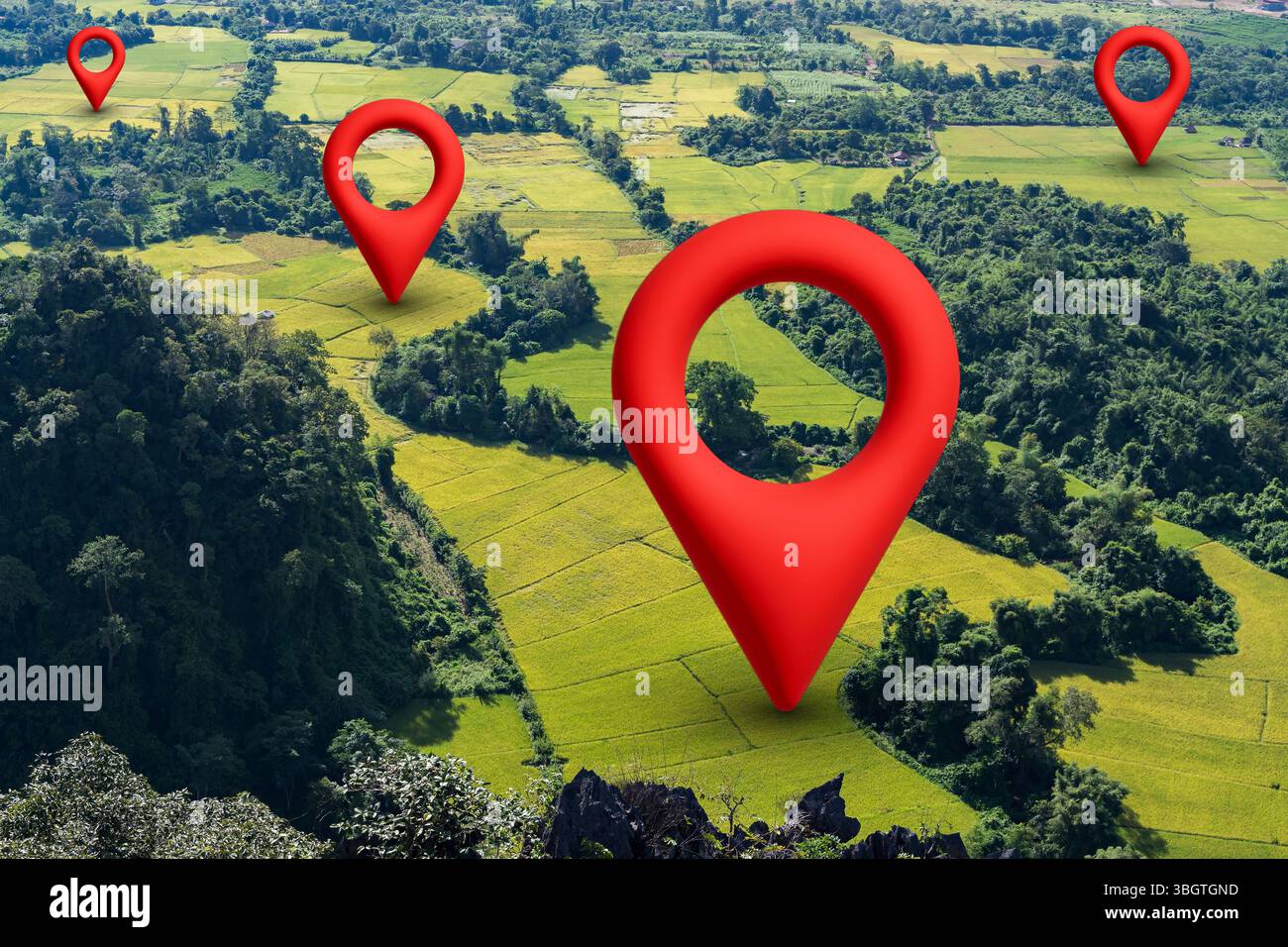 Aerial view of rice fields and forest with red location pin icons. Concept of GPS navigation, map positioning, digital tracking, land management, agri Foto Stock