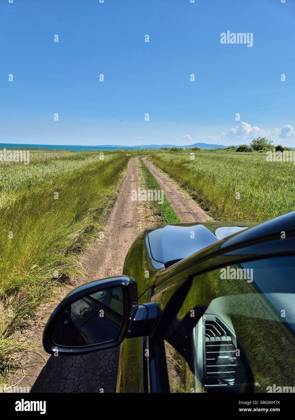 auto sulla strada tra i campi. strada che porta al mare. giornata di sole. estate - Immagine stock catturata con smartphone