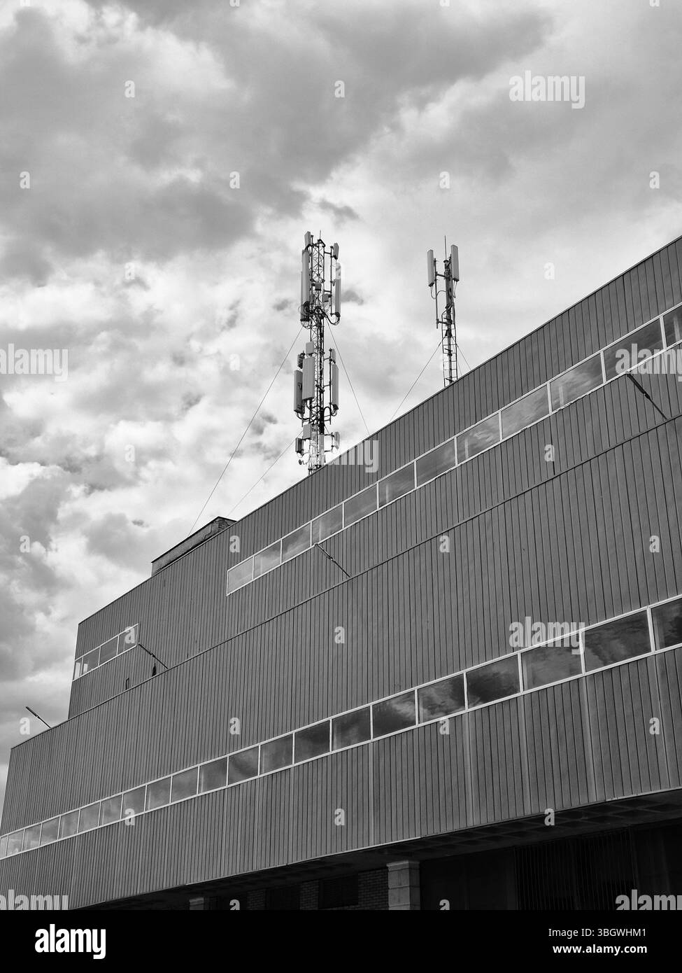 Torri di telefonia mobile, torri di telecomunicazione sul tetto di un'impresa industriale. foto in bianco e nero Foto Stock