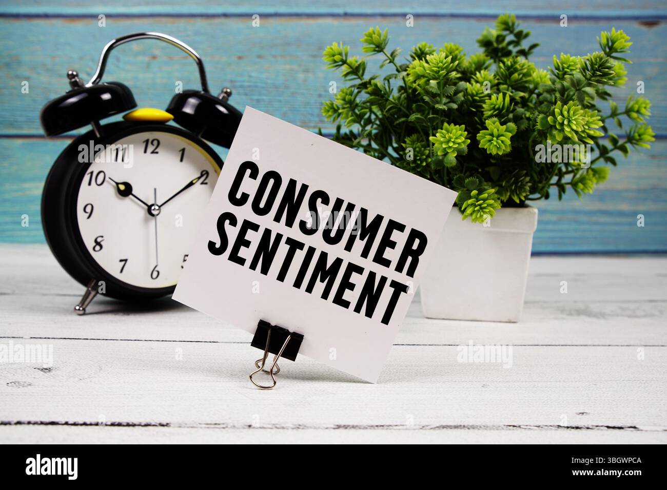 Testo del sentimento del consumatore scritto su carta con sveglia su sfondo di legno Foto Stock