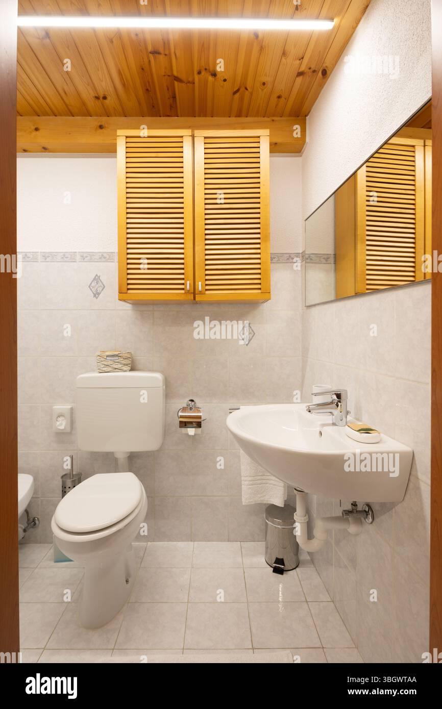 Bagni interni moderni rinnovati in un vecchio edificio tipicamente italiano con soffitto in legno. Tutto è nuovo e molto pulito Foto Stock