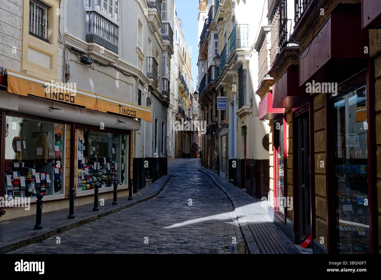 Cadice - stretta via dello shopping fiancheggiata da condomini. Foto Stock