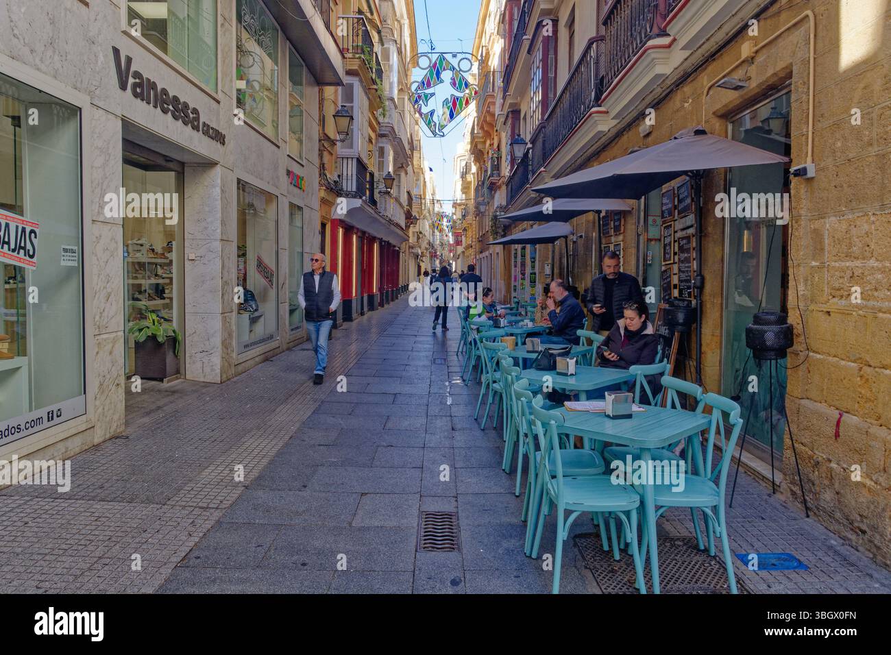 Cadice - strada pedonale con tavoli da caffe' marciapiede e sedie. Negozi e clienti. Foto Stock