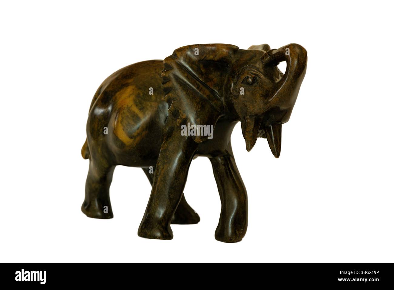 Un tradizionale elefante africano in pietra intagliato a mano, isolato su uno sfondo bianco Foto Stock